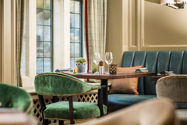 Grey's Restaurant interior with warm lighting, tiled flooring, and French doors opening onto the courtyard